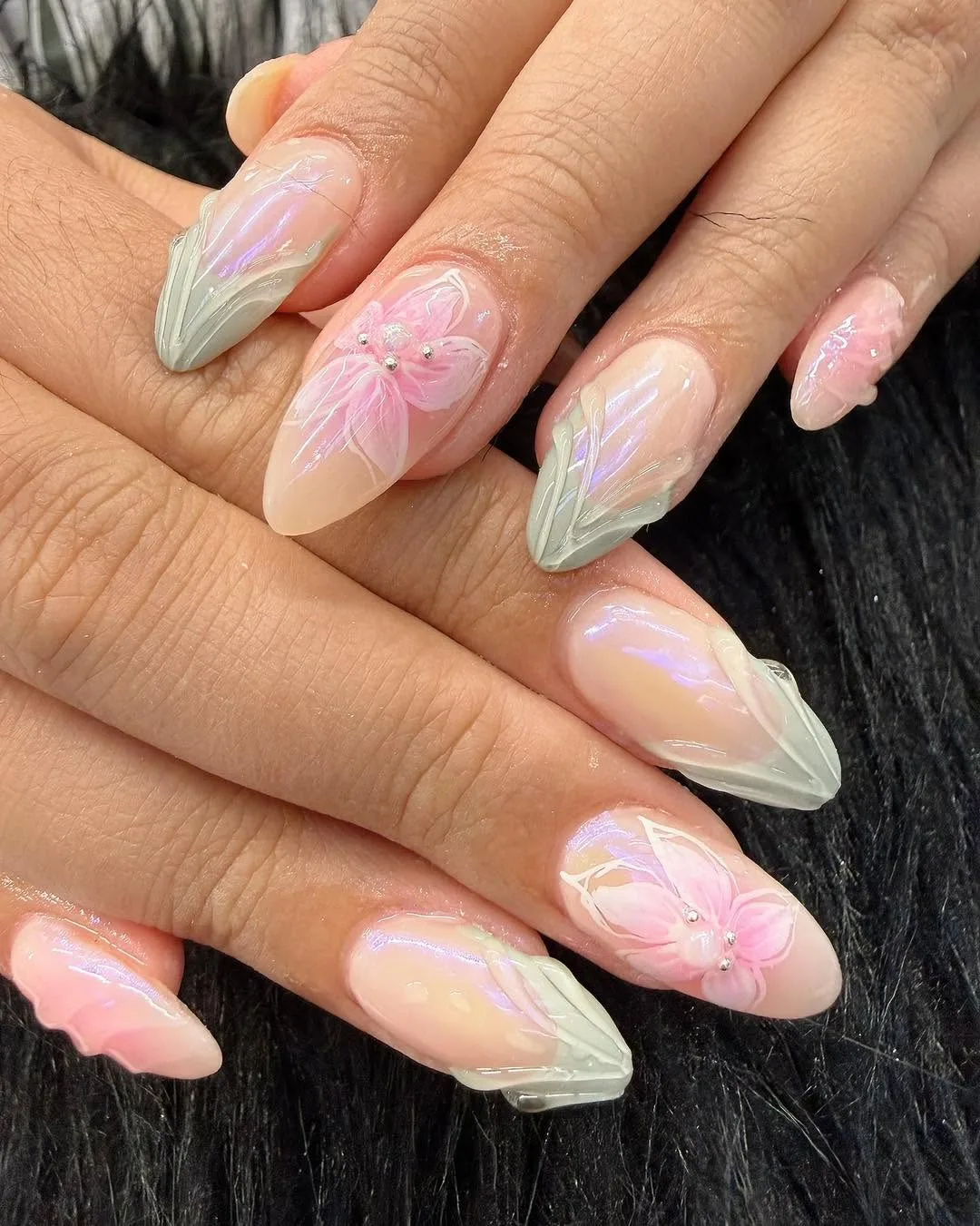 Nude almond nails with iridescent aura finish and 3D pink lily sculpted art with pearls