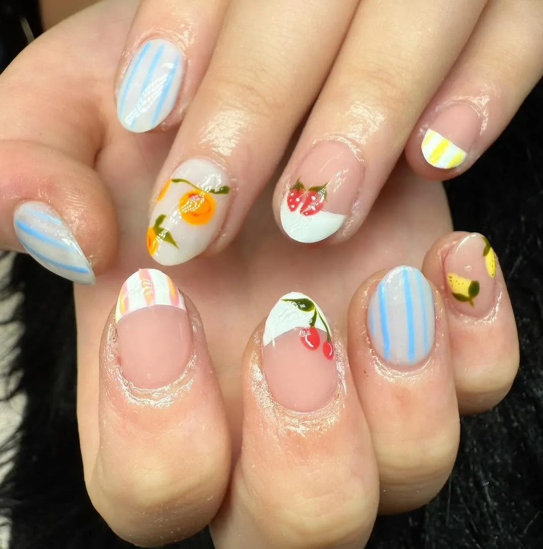 Short round nails with summer fruit theme — oranges, cherries and strawberries